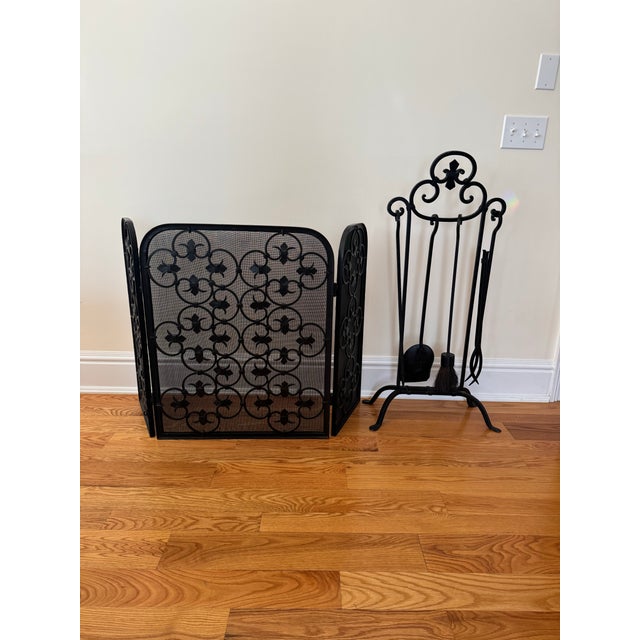 An elegant and functional vintage Spanish revival wrought iron folding fireplace screen. Scrolls of dark black iron backed...