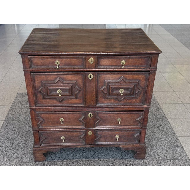 This antique William & Mary chest of drawers was hand-crafted from black oak wood in the 18th Century. The wood has a warm...