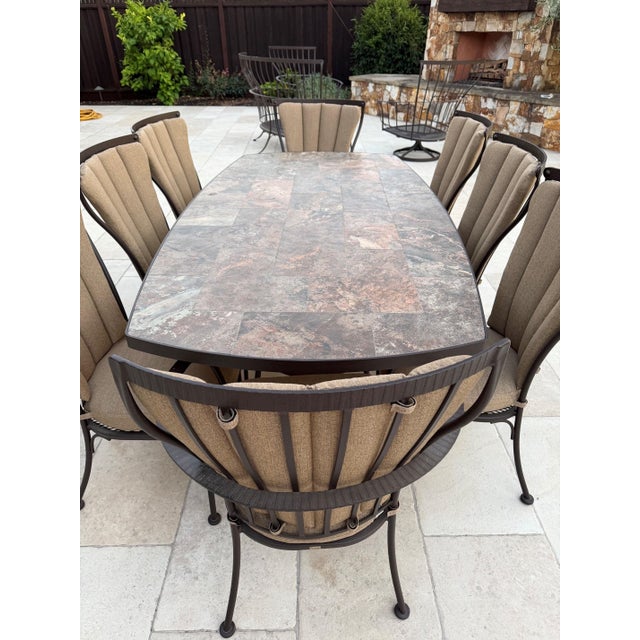 A substantial nine-piece outdoor dining set from O.W. Lee's Monterra collection, the California maker's hand-forged...