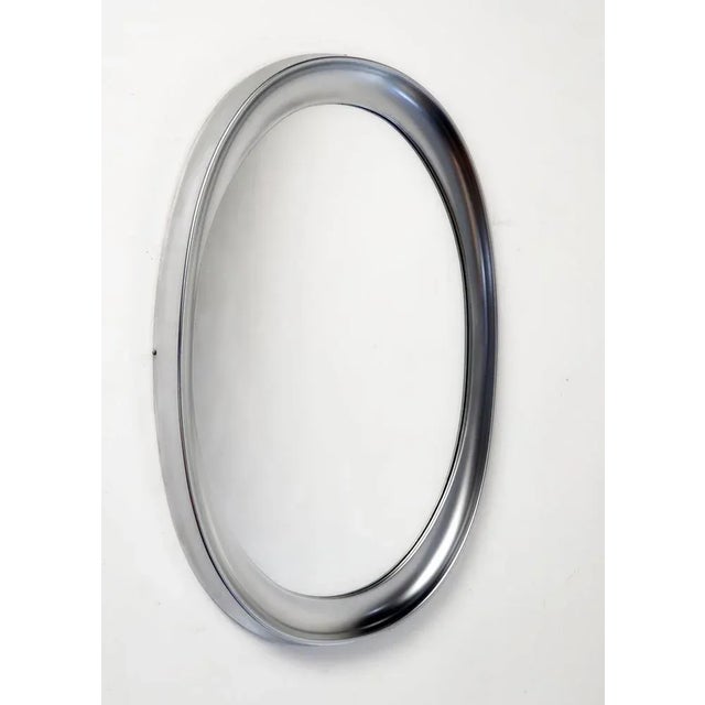 Mid-century large oval wall mirror from the "Narciso" serie by Sergio Mazza for Artemide, 1960s. The material in the frame...
