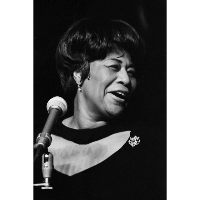 This striking black-and-white photograph captures the legendary jazz singer ella fitzgerald during a live performance in...