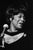 This striking black-and-white photograph captures the legendary jazz singer ella fitzgerald during a live performance in...