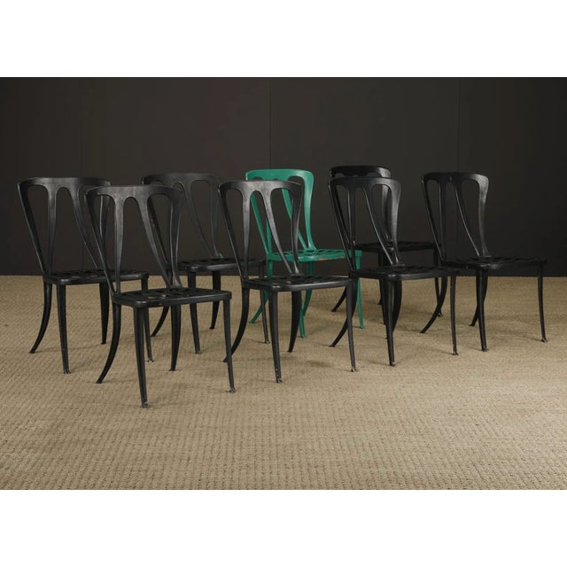 Striking set of eight vintage metal café chairs in the iconic Tolix-style industrial design, featuring sculptural cutout...