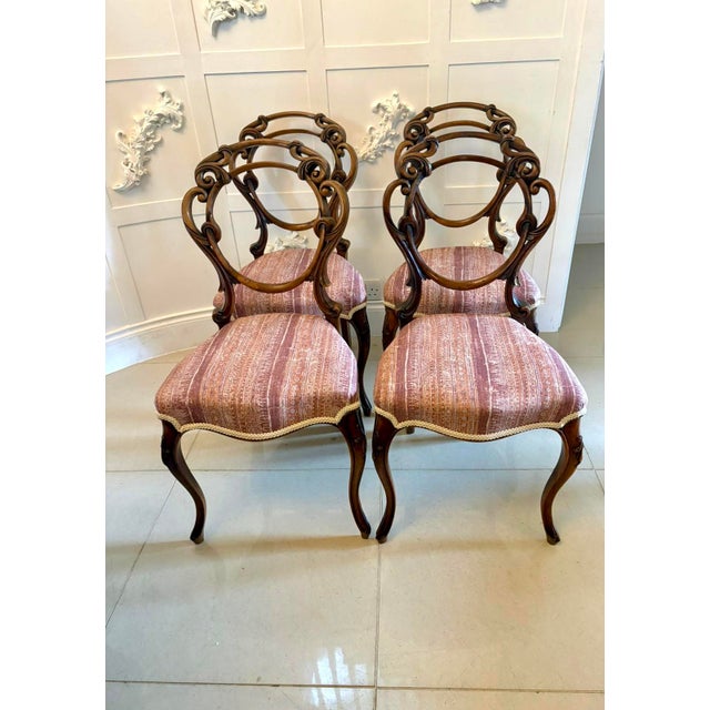A very attractive set of four Victorian carved walnut dining chairs with elegant balloon backs and beautifully flowing...