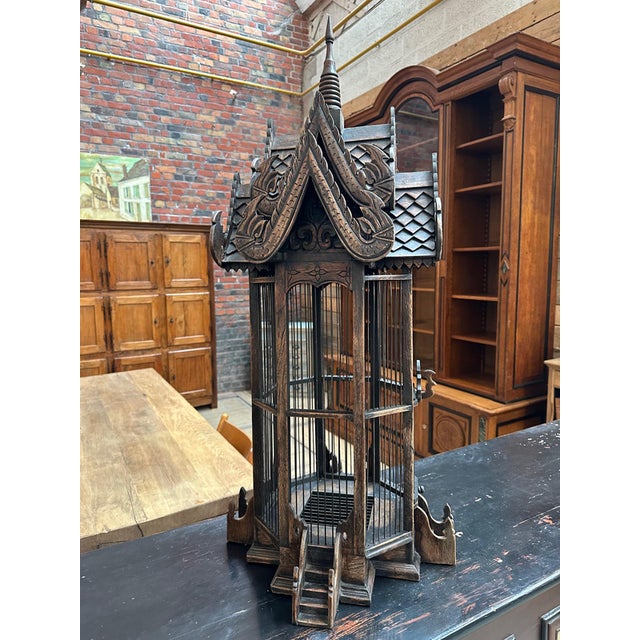 Beautiful carved teak cage inspired by Indonesian design. The woodwork makes it a work of art, both in its details and the...