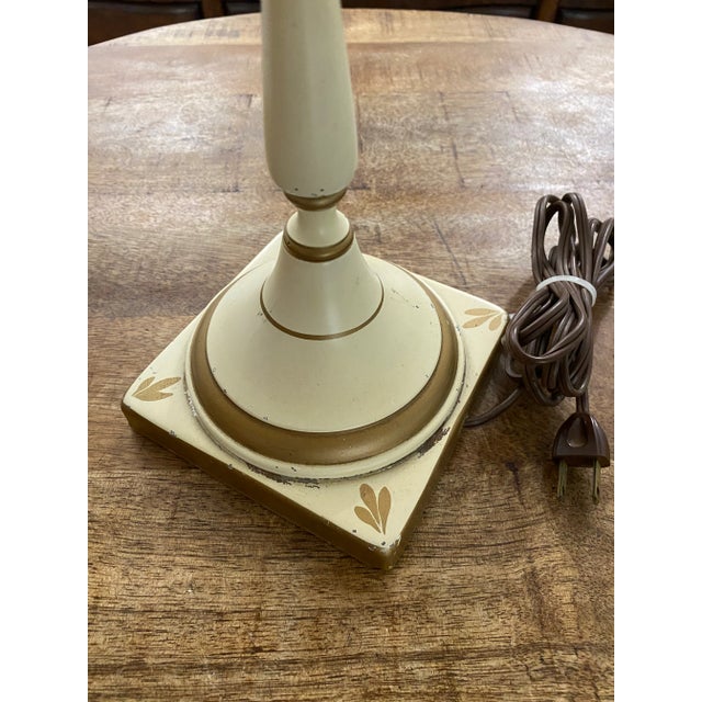 Classic vintage toleware library lamp in creamy off white with painted gold accents. Original metal shades sits...