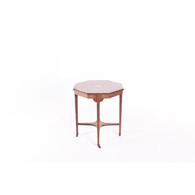 This English side table is made of santo wood and features inlays.