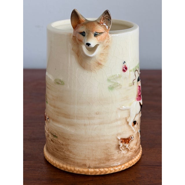 Very unique Fox hunt pitcher featuring beagles, riders and horses, embossed on the pitcher with a fox head for the spout...