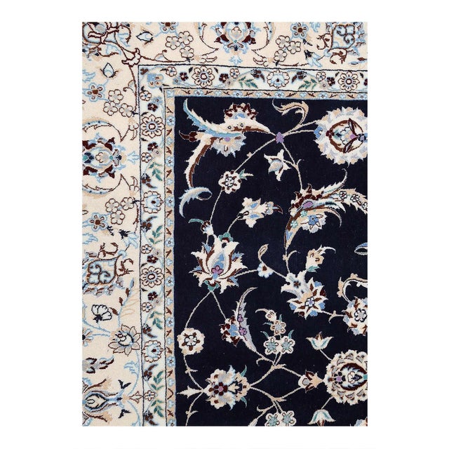 Persian Nain rugs are renowned for their detail and fine use of outlining along the central motifs. Breaking from the...