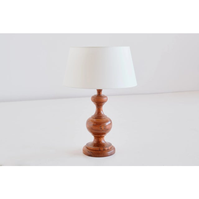 This rustic and elegant table lamp was produced in France in the 1950s. The lamp is made of solid oakwood displaying a...