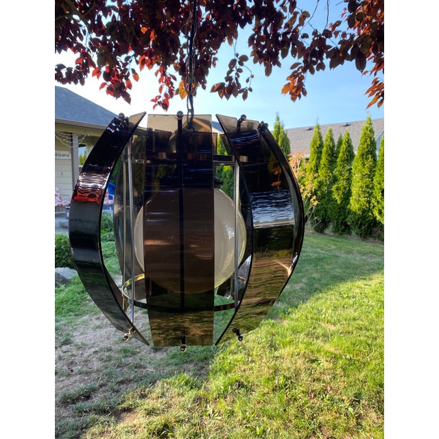 A milky white glass globe is suspended within a chrome frame upon which 9 smoked lucite panels are attached at the top and...