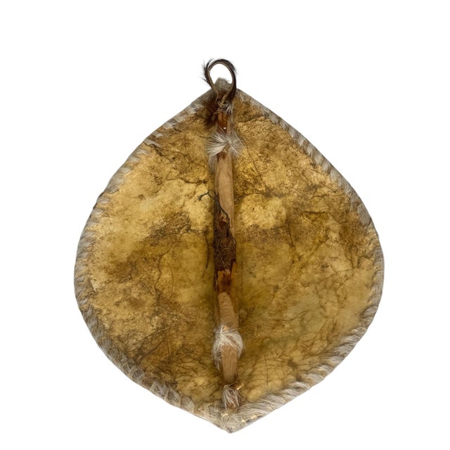 A striking piece of East African decorative and ceremonial art, a hand-shaped and painted animal hide shield or wall...