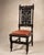 An impressive pair of antique Jacobean Revival carved oak hall chairs featuring elaborate openwork backs with heraldic...