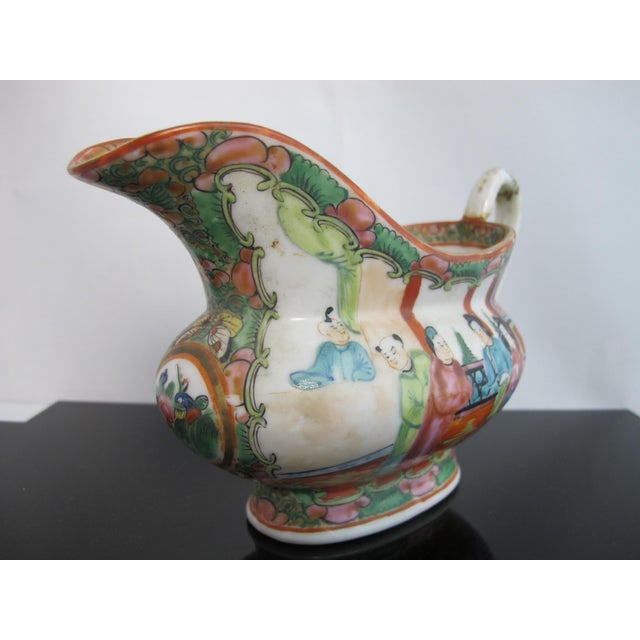 Early 20th century Chinese Famille Rose gravy boat pitcher. Heavy porcelain with hand painted figural design on one side...
