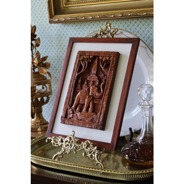 A beautifully detailed vintage Southeast Asian teak bas-relief depicting an elephant before a tiered temple complex,...