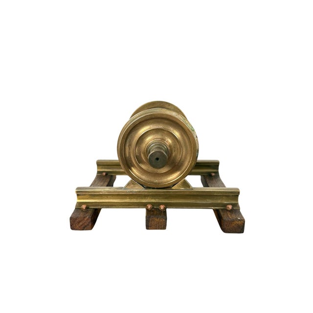 A decorative vintage brass railway wheelset mounted on a short section of track with wooden sleepers. The model features a...