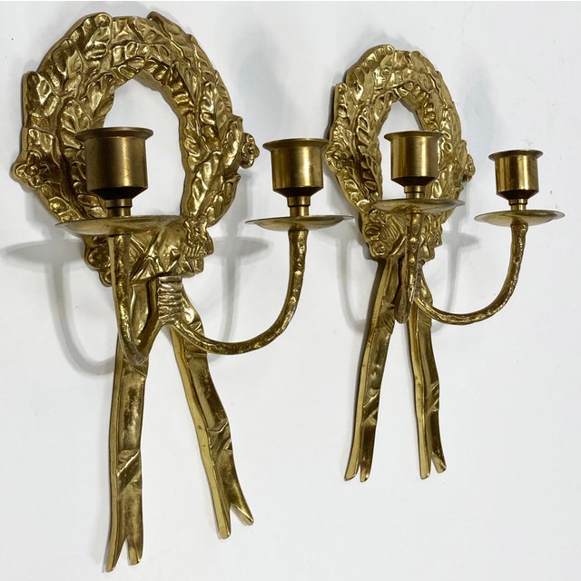Vintage non-electrified brass wall sconces featuring Laurel wreath design with trailing ribbons. Each sconce holds two...