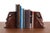 Handmade leather bookends in a primitive face shape — because why have normal bookends when you can have these staring...