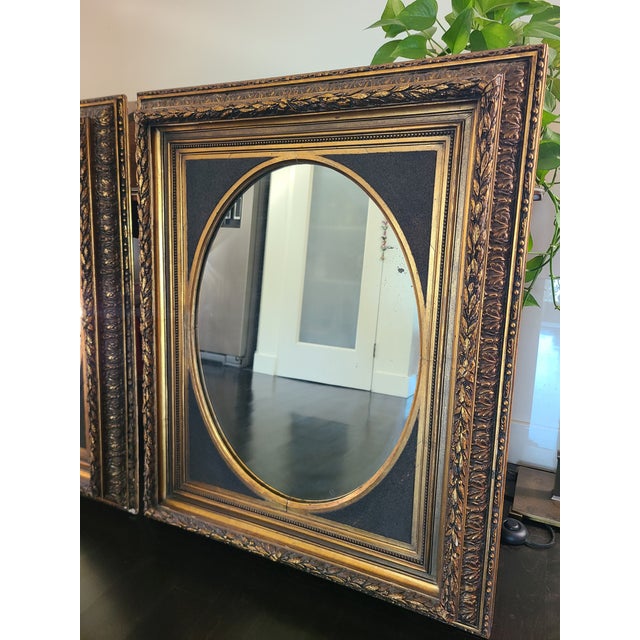 Stunning pair of neoclassical style mirrors crafted from wood and gesso. Each features an intricate gilt leaf design for...