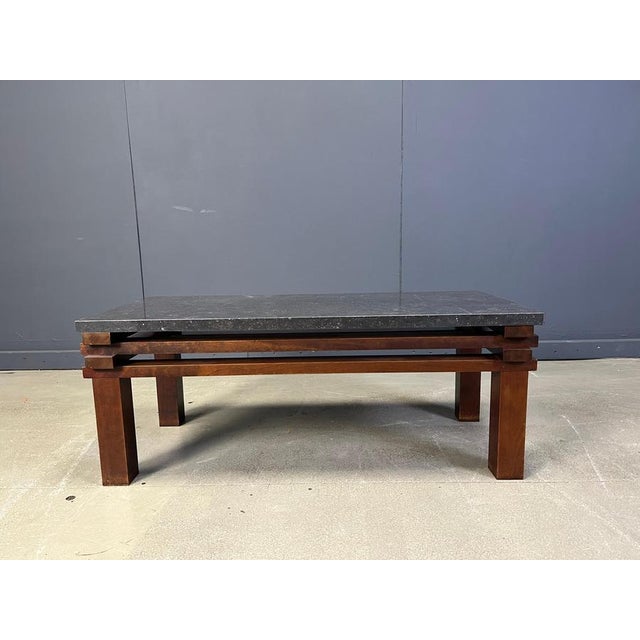 Beautiful wooden coffee table with a black stone table top. This coffee table has a cool interlocking frame very much...