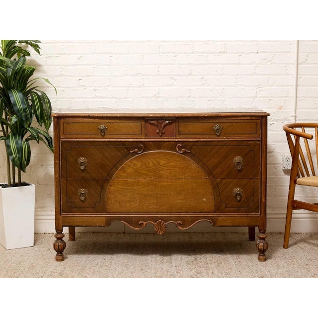 A handsome vintage dresser with strong Art Deco influence, featuring a broad low-profile case, decorative geometric veneer...