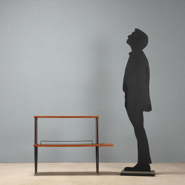 1960s cabinet embodying the essential and functional design typical of the era. The slender black enameled metal legs...