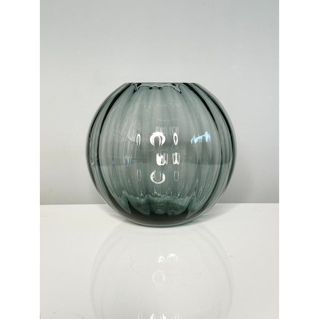 This blue-gray spherical glass vase from the Turmalin series was designed and manufactured by Wilhelm Wagenfeld...