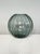 This blue-gray spherical glass vase from the Turmalin series was designed and manufactured by Wilhelm Wagenfeld...