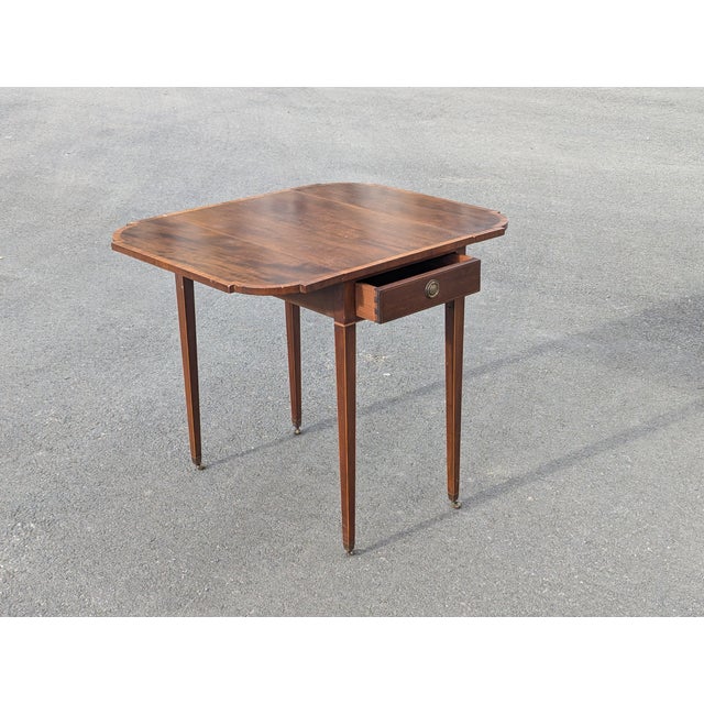 Elevate your interior with the timeless elegance of this authentic Federal style mahogany Pembroke drop-leaf table....
