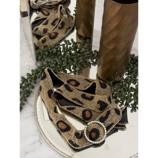 This vintage belt features a bold leopard print crafted from metallic gold, bronze, and tan seed beads, with black bead...