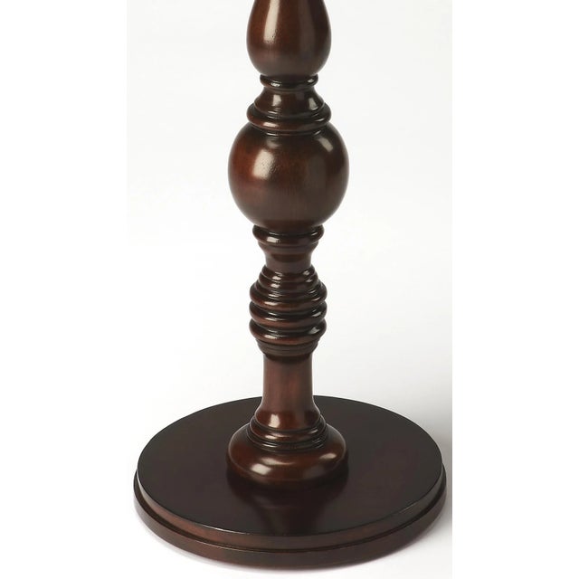 Elaborately carved pedestal connects the base with the tabletop to create a compelling aesthetic for a favorite nook or...