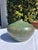 Vintage green studio pottery vessel with organic rounded form and narrow mouth opening. Signed on the underside. The glaze...