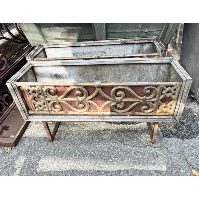 Original vintage cast iron balustrade railing panel inset into old wood box. Iron handles and iron U shape support legs....