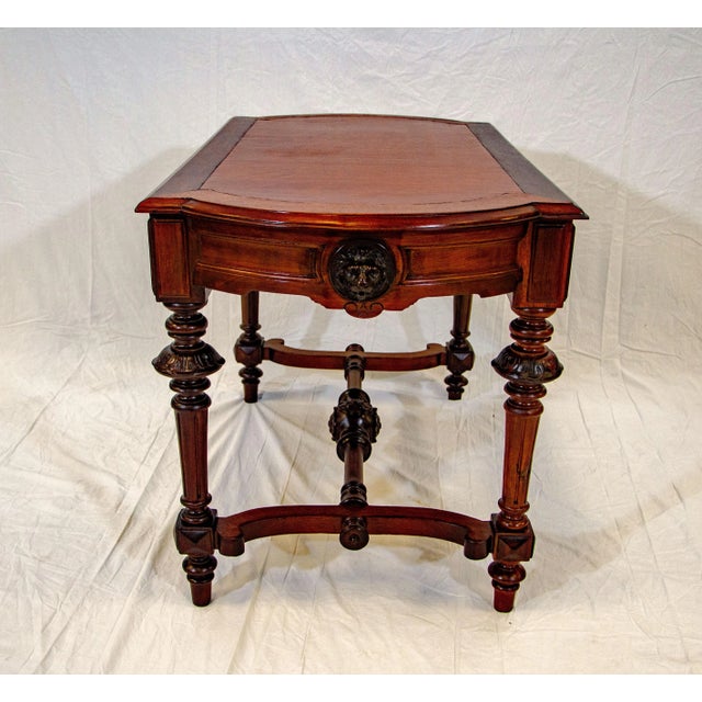 Multi-purpose victorian walnut table with leather inset. The top surface has straight sides and rounded ends. There are...