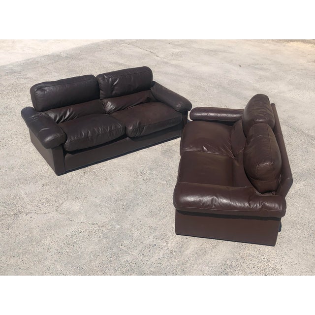 Pair of vintage 3-seater sofas in chocolate brown leather by Tito Agnoli, dating from the 1970s. The cushions are feather-...