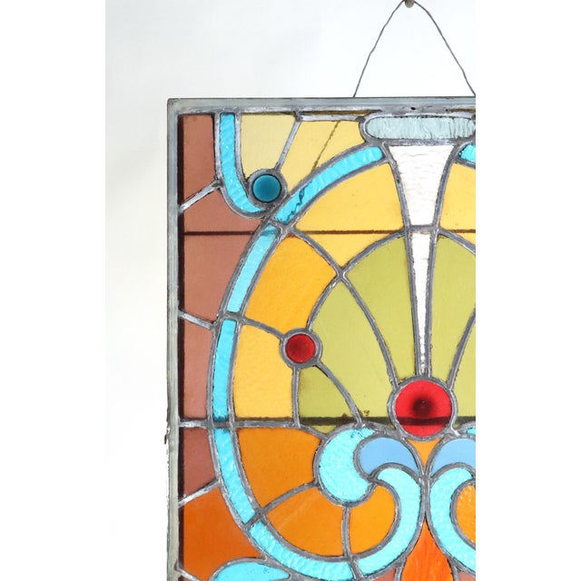 Early 19th century stained glass panel with flowing organic lines and vivid colors, traits of Art Nouveau styling. There...