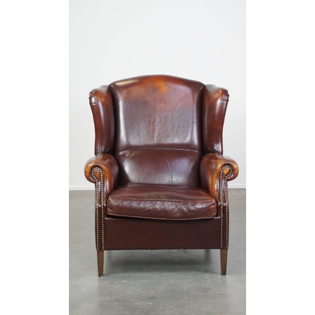 Offered is this classic, luxurious and comfortable dark English style sheep leather ear chair with lots of character and a...