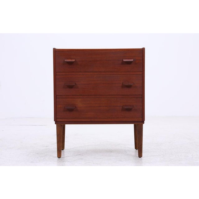 Vintage teak chest of drawers in classic 1960s Danish design. The three spacious drawers offer practical storage space,...