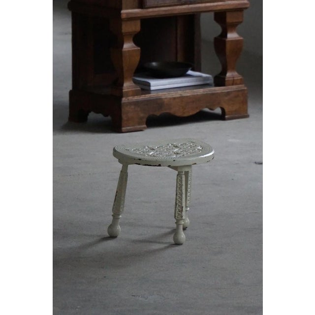 A charming late 19th to early 20th century wooden stool, crafted from solid wood and finished in patinated white paint....