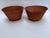 A matching pair of round tole bowls or cachepot featuring a terracotta style finish and three ball feet.