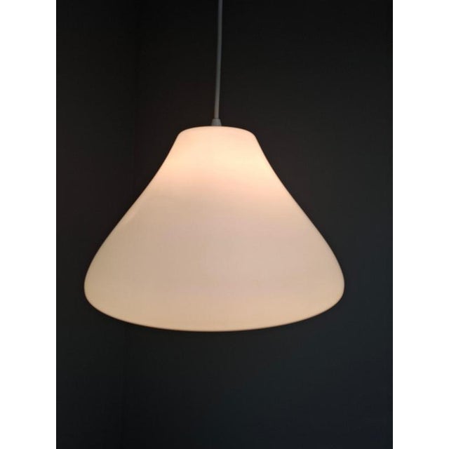 Elegant midcentury modern pendant light produced in czechoslovakia during the 1970s. The lamp combines opaline glass with...