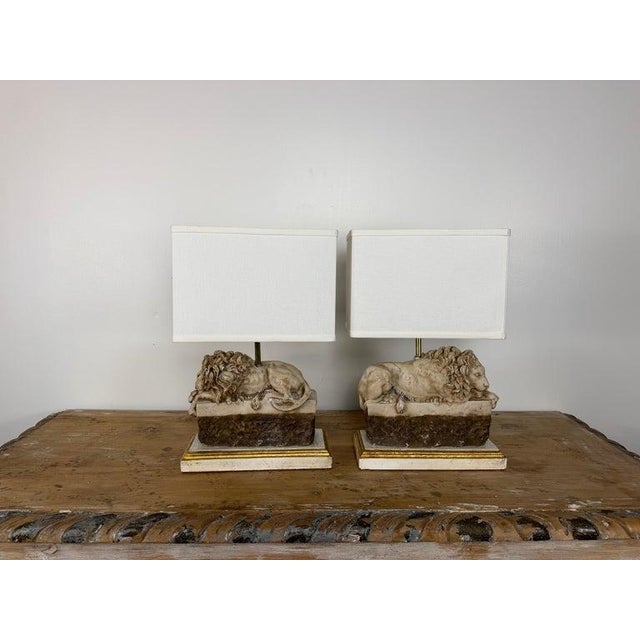 A superb and highly sculptural pair of Neoclassical table lamps in the form of recumbent lions, after the iconic 19th-...