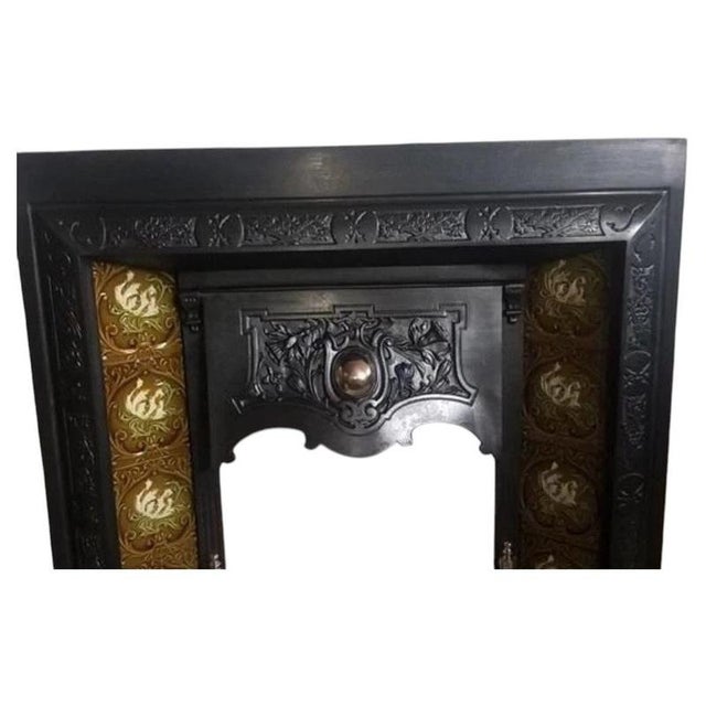 A magnificent original antique cast iron fireplace insert retaining its beautiful original decorative tiles, combining...
