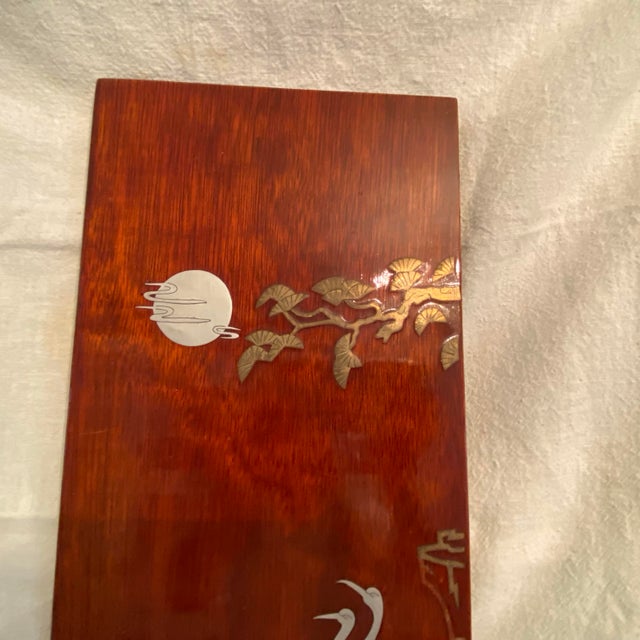 Asian wall hanging panel imade of wood with brass and silver stamped cut and placed on a dark stained mahogany with a...
