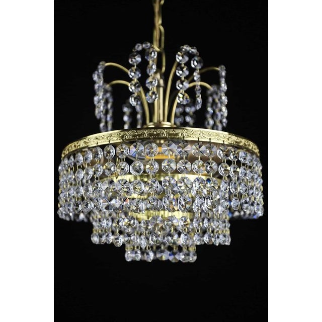 Brass chandelier with crystal pendants that will brighten up the interior in moha colors. The pendants are made of hand-...