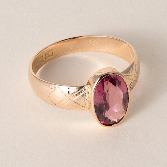 Vintage ring featuring a vivid pink oval-cut tourmaline bezel set in solid 18K rose gold. Circa 1974 This ring is notable...