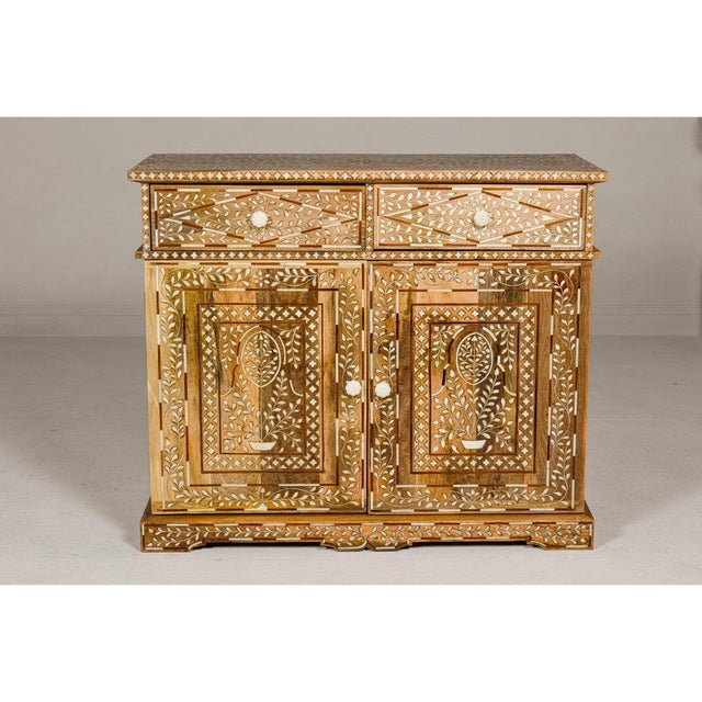 This Anglo-Indian style mango wood buffet exemplifies craftsmanship and artistic design through functional storage...