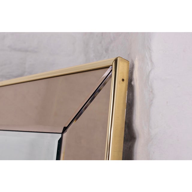 Large rectangular beveled mirror with smoked glazing bead, framed with gilded rods. 1970s edition. Maximum height 115 cm x...