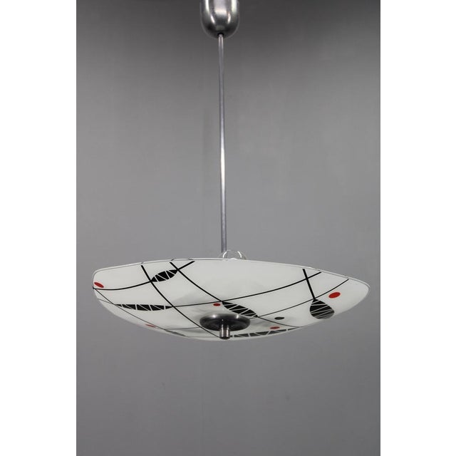 This distinctive mid-century pendant chandelier was produced in czechoslovakia in the 1970s. It features a chromed metal...