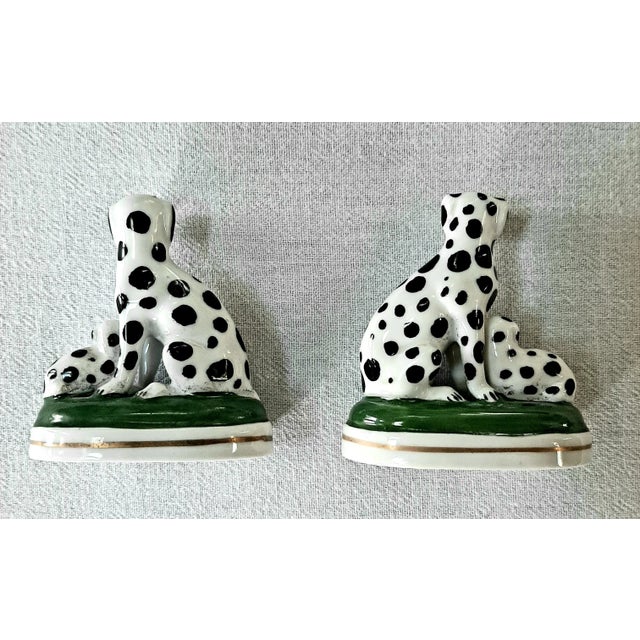 Pair of 19th Century Staffordshire, English dogs. Each depicts a large Mother dog with a pup. Each sit on a green base...